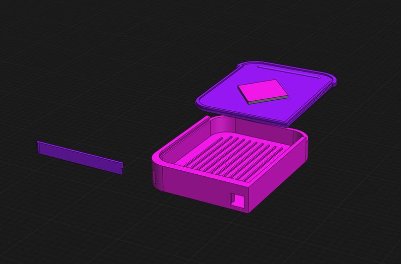 Puede incluir: Una caja de pl&aacute;stico morada con una tapa extra&iacute;ble y un compartimento cuadrado en el interior. La caja tiene un fondo acanalado y est&aacute; dise&ntilde;ada para guardar objetos peque&ntilde;os.