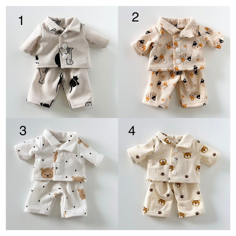 Puede incluir: Cuatro conjuntos de pijamas para mu&ntilde;ecas, cada uno con un estampado de animal diferente. Los pijamas son beige con estampados de animales negros, naranja y marrones. Los pijamas est&aacute;n numerados del 1 al 4.