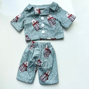 Puede incluir: Un conjunto de pijama azul y blanco con estampado de oso polar. La parte superior tiene un frente abotonado y mangas cortas. Los pantalones tienen una cintura el&aacute;stica.