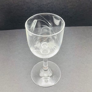 May include: A clear glass stemmed shot glass with a delicate etched design of wheat stalks.