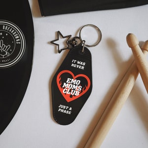 May include: Black keychain with a red heart and the text "It was never Emo Moms Club Just a Phase".