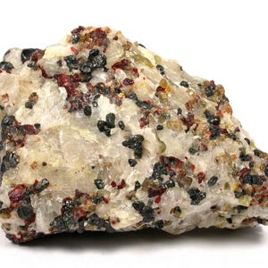 Pode incluir: Um espécime mineral bruto apresentando uma matriz de quartzo cristalino branco incrustada com pequenas inclusões distintas de granada vermelho-profundo, cristais amarelo-esverdeados translúcidos e grãos minerais metálicos pretos opacos.