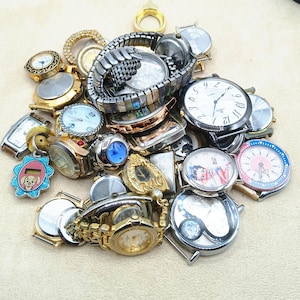 K&ouml;nnte beinhalten: Eine Sammlung verschiedener Armbanduhren und Uhrenteile in diversen Ausf&uuml;hrungen, darunter gold- und silberfarbene Modelle sowie Metallgliederarmb&auml;nder. Der Haufen enth&auml;lt runde und rechteckige Zifferbl&auml;tter, teils mit verzierten L&uuml;netten.