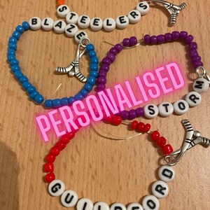 Könnte beinhalten: Drei personalisierte Hockey-Armbänder mit den Namen "Blaze", "Steelers", "Storm" und "Guildford". Jedes Armband hat einen silbernen Hockeyschläger-Anhänger.