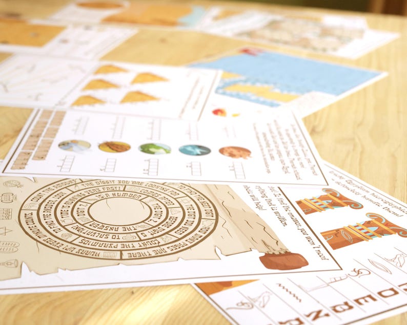 May include: A collection of printed papers with illustrations and text, including a circular design with text and a scroll-like element. The papers feature various graphics and text, with a focus on a tan and brown color scheme. The papers are arranged on a light brown wooden surface.