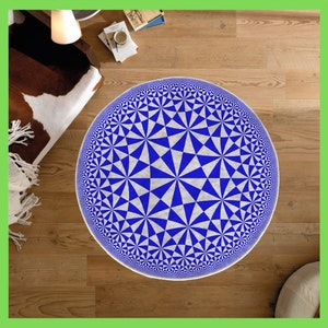 May include: A blue and white geometric patterned rug with a circular design. The rug is on a wooden floor.
