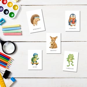 May include: Set of six illustrated cards featuring watercolor animals expressing different emotions. The cards include a hedgehog, penguin, deer, turtle, and frog. Each card has a German word describing the animal's emotion.