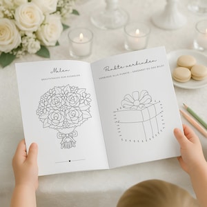 May include: An open book with two pages of line drawings. One page shows a floral bouquet with the word "Malen" above it. The other page has a connect-the-dots drawing of a gift with the words "Punkte verbinden" above it.
