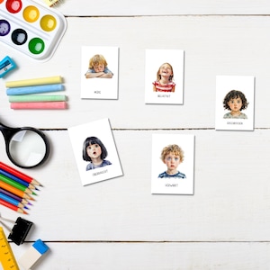 May include: Five white cards with illustrations of children's faces and words describing their emotions. The words are "Muse", "Delighted", "Embarrassed", "Upset", and "Confused".