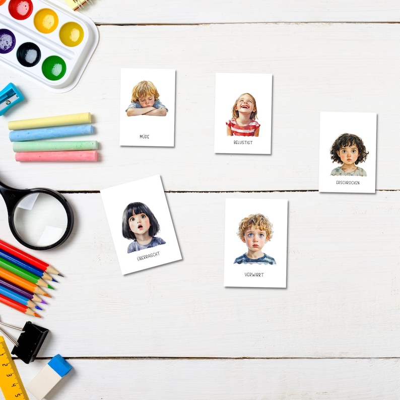 May include: Five white cards with illustrations of children's faces and words describing their emotions. The words are "Muse", "Delighted", "Embarrassed", "Upset", and "Confused".