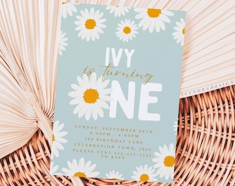 May include: A blue and white invitation with a daisy pattern. The text reads "IVY is turning ONE" and includes details for a birthday party on September 28th.