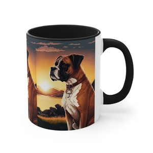 May include: A white ceramic mug with a black rim and handle. The mug features a colorful illustration of a boxer dog sitting in a scenic landscape with a sunset in the background.