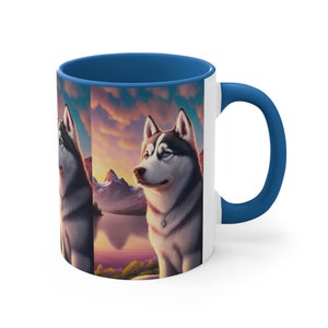 Puede incluir: Una taza de cerámica blanca con un borde y un asa azules. La taza presenta una ilustración colorida de un perro Husky siberiano sentado en un paisaje de montaña con un lago y una puesta de sol en el fondo.