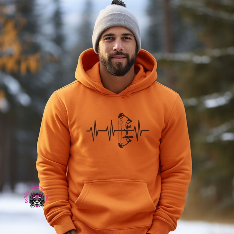 May include: Orange hoodie with a black heartbeat graphic featuring a bow and arrow.