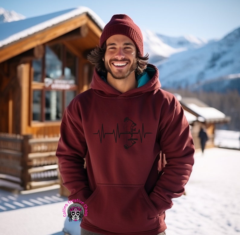 May include: A maroon hoodie with a black graphic of a bow and arrow inside a heartbeat. The hoodie has a drawstring hood and a kangaroo pocket.