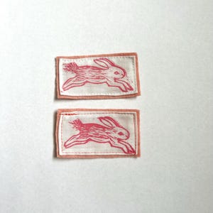 May include: A white ceramic mug with a black handle and the text "But First, Coffee" in a bold, black font. The mug is set against a blurred background, suggesting a cosy setting.