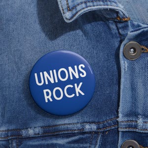 May include: A blue button with white text that reads "UNIONS ROCK" on a denim jacket.