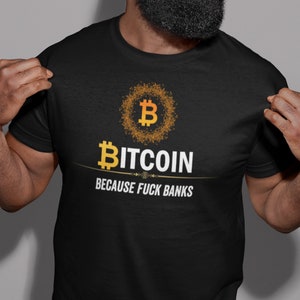 Op de afbeelding: Zwart T-shirt met een gouden Bitcoin-logo en de tekst "Bitcoin Because Fuck Banks".