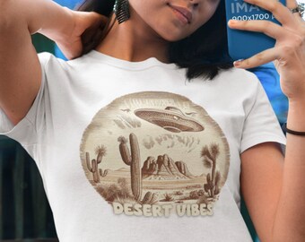May include: White t-shirt with a brown graphic of a desert landscape with a flying saucer, cacti, and mountains. The text "Desert Vibes" is printed below the graphic.