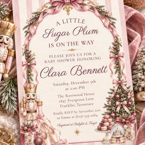 May include: A rectangular baby shower invitation card with a pink and white striped background, featuring a decorative arch of pine branches, pink ribbons, and a nutcracker illustration. The text reads A Little Sugar Plum Is On The Way, Clara Bennett, Saturday, December 5th, 2:00 PM, The Rosewood House, 1847 Evergreen Lane, Franklin, Tennessee, RSVP by November 21st to Emma at (615) 555-0184, Registered at Babylist & Target.