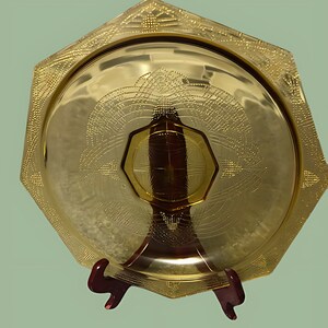 May include: A yellow glass octagonal serving dish with a raised geometric pattern. The dish is on a wooden stand.