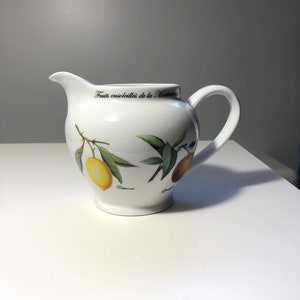 May include: White ceramic pitcher with a handle, featuring a lemon tree design with the text "Fruits ensoleillées de la Mediterranée" and "Citrons".
