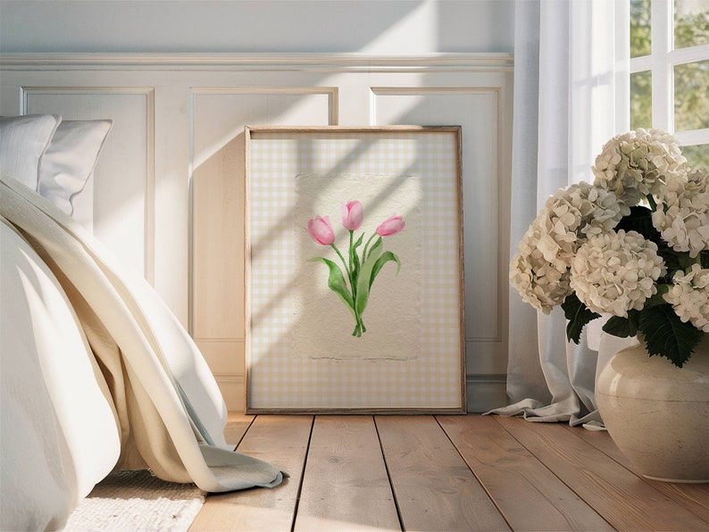 Pode incluir: Uma impress&atilde;o de arte emoldurada apresentando uma ilustra&ccedil;&atilde;o em aquarela de tr&ecirc;s tulipas cor-de-rosa com caules e folhas verdes, centralizada em um fundo de papel off-white texturizado com uma borda de padr&atilde;o xadrez vichy amarelo claro e branco.