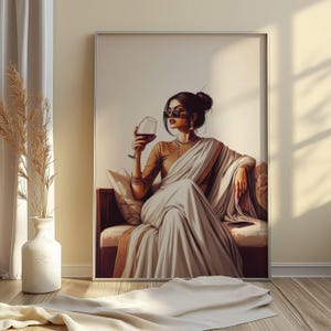 Puede incluir: Una obra de arte enmarcada representa a una persona con un sari blanco, blusa dorada y gafas de sol, sosteniendo una copa de vino tinto. La obra est&aacute; ambientada sobre un fondo neutro, con un sof&aacute; y un jarr&oacute;n con plantas secas en primer plano.