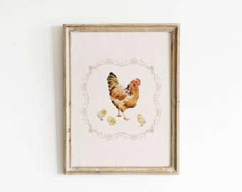 May include: Framed watercolor print featuring a hen and three chicks. The hen has brown, orange, and yellow feathers and a red comb. The chicks are yellow. The artwork is surrounded by a green floral border and framed in a light brown wooden frame.
