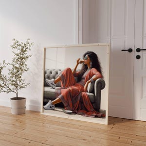 May include: A framed artwork depicts a person in a coral-colored outfit, seated on a gray sofa, wearing sunglasses and white sneakers. The artwork is leaning against a white wall next to a potted plant and a white door.