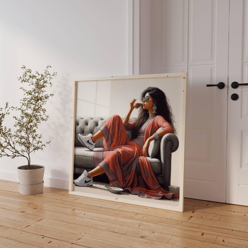 May include: A framed artwork depicts a person in a coral-colored outfit, seated on a gray sofa, wearing sunglasses and white sneakers. The artwork is leaning against a white wall next to a potted plant and a white door.