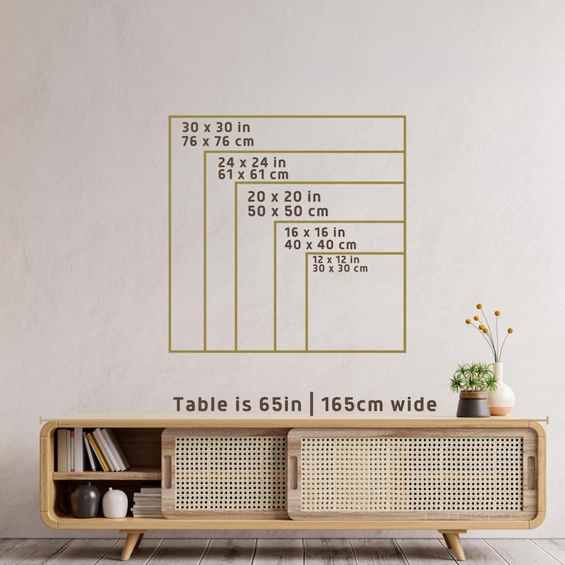 May include: A display of framed artwork sizes, including 30x30 inches (76x76 cm), 24x24 inches (61x61 cm), 20x20 inches (50x50 cm), 16x16 inches (40x40 cm), and 12x12 inches (30x30 cm). The text "Table is 65in | 165cm wide" is also present.