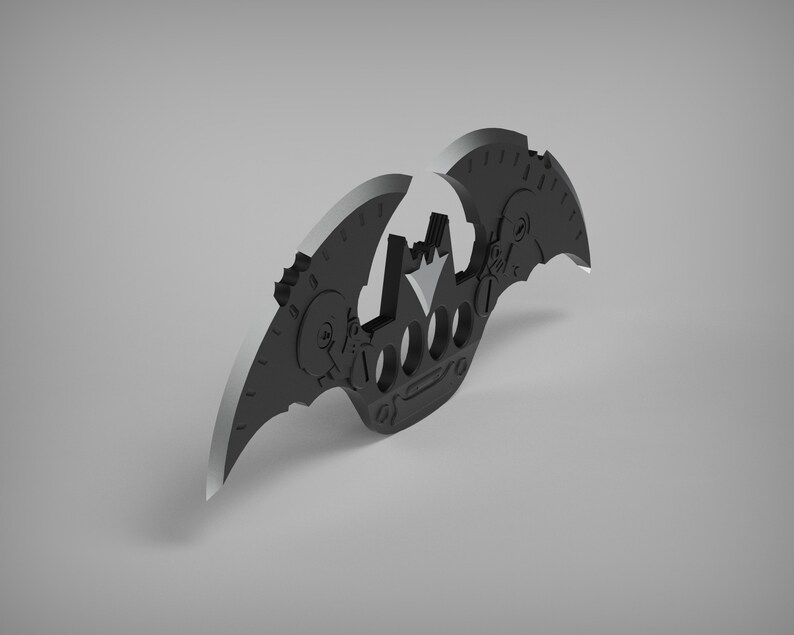 May include: A black metal bat-shaped keychain with a crown design and a gear-like pattern on the wings.
