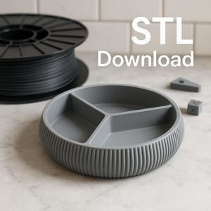 Può includere: Un piatto grigio a tre scomparti con un bordo testurizzato. Il piatto è realizzato per la stampa 3D ed è disponibile per il download come file STL.