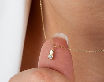 May include: A delicate gold necklace with a small diamond and a star charm.