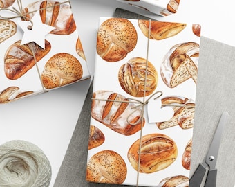 May include: Four gift boxes wrapped in white paper with a repeating pattern of various breads and rolls. The boxes are on a light gray surface with a white string and a white tag on one of the boxes.