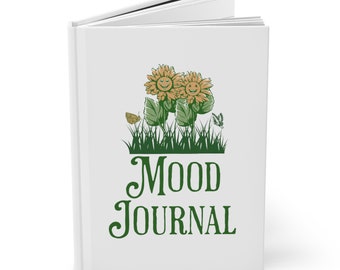 May include: White book with a green and yellow sunflower design and the text "MOOD JOURNAL" on the front cover.