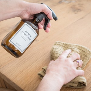May include: A brown glass bottle with a black spray nozzle and a white label that reads "Pschitt a Tout Faire Pure & Naturel LAVANDOU  F."