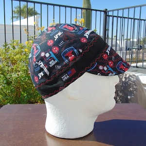 May include: Black welding cap with a red, blue, and white Spiderman pattern. The cap has the text "Spiderman", "Web Slinger", and "Made in USA".