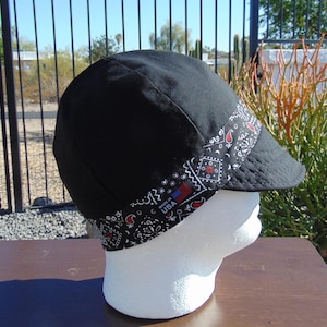 May include: Black welding cap with a paisley bandana trim. The bandana trim features a red, white, and blue "Made in USA" label.