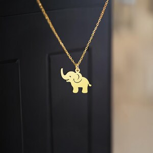 K&ouml;nnte beinhalten: Eine goldene Kettenkette mit einem Elefantenanh&auml;nger. Der Elefant ist nach rechts gerichtet und hat seinen R&uuml;ssel erhoben.