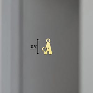 以下が含まれることがあります： ハートと文字Aがついたゴールドチャーム。高さ1.27cmです。