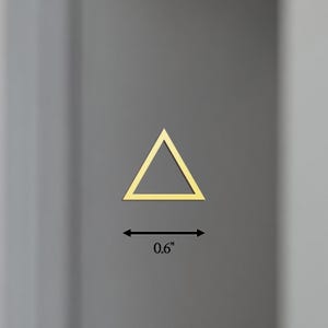 Puede incluir: Un tri&aacute;ngulo dorado con un ancho de 1,5 cm. El tri&aacute;ngulo est&aacute; bordeado de oro y se encuentra sobre un fondo gris.