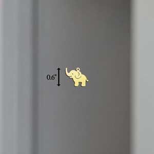 K&ouml;nnte beinhalten: Goldfarbener Elefanten-Anh&auml;nger aus Metall, 1,5 cm hoch.