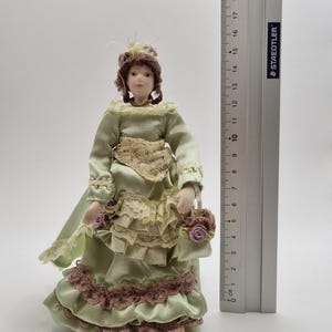 Muñeca con vestido victoriano y bolso para casa de muñecas.
