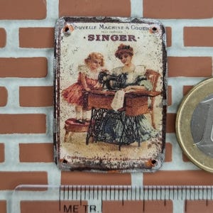 Cartel publicitario de imitación esmaltado con efecto envejecido de máquinas de coser Singer.