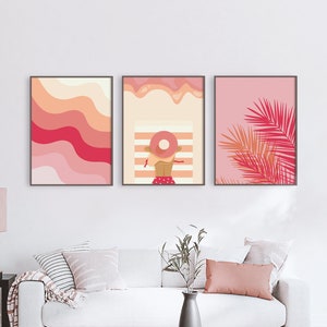 3 pink preppy posters with illustrations hangs on the wall in a living room above the beige sofa
