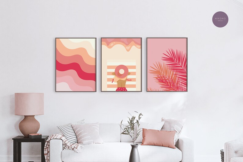 3 pink preppy posters with illustrations hangs on the wall in a living room above the beige sofa