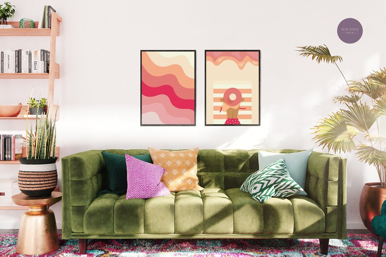 Pink preppy poster set with illustrations hangs on the wall in a living room above the green sofa
