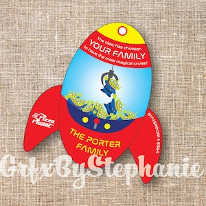 Puede incluir: Un juguete en forma de cohete rojo y amarillo con una máquina de garras en su interior. La garra está sosteniendo un juguete alienígena verde. El texto en el juguete dice "The claw has chosen your family to have the most magical cruise!" y "Pizza Planet".